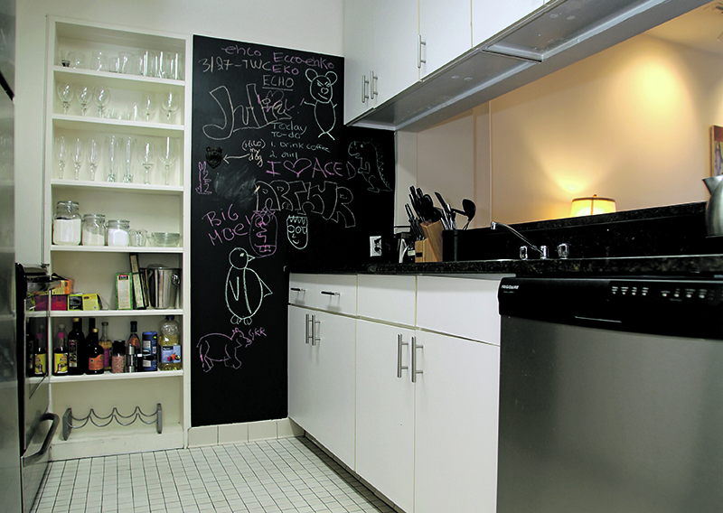 Arthur Dessin and Julie Albanese added their own touches to the kitchen of their Armory Square apartment, including the cabinet hardware and painting part of a wall with chalkboard paint. (Gloria Wright Photo | Syracuse New Times)