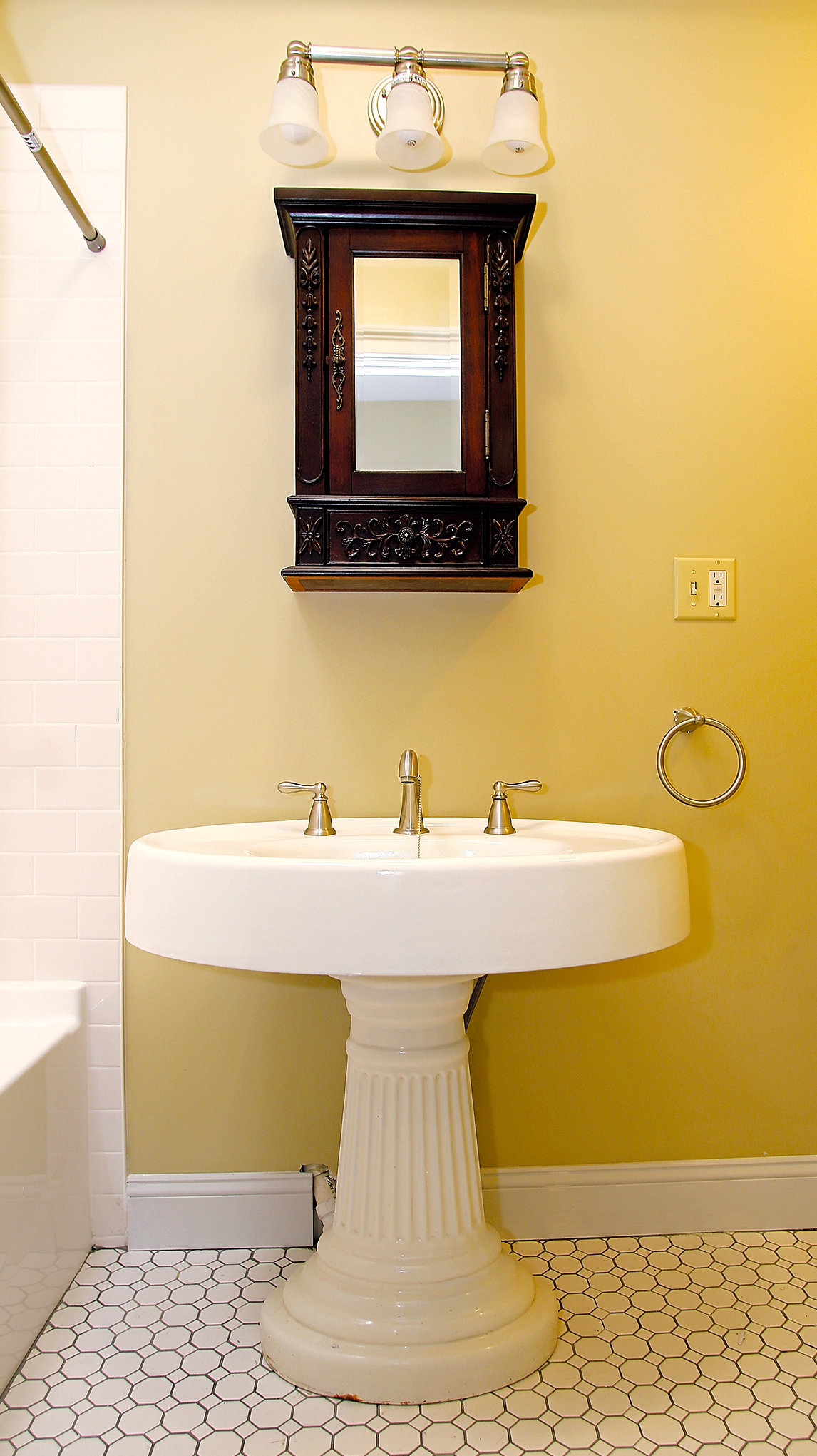 The original sink was refurbished and new floor tile chosen tht matches the original tile in the bathroom at 537-539 N. Salina St.