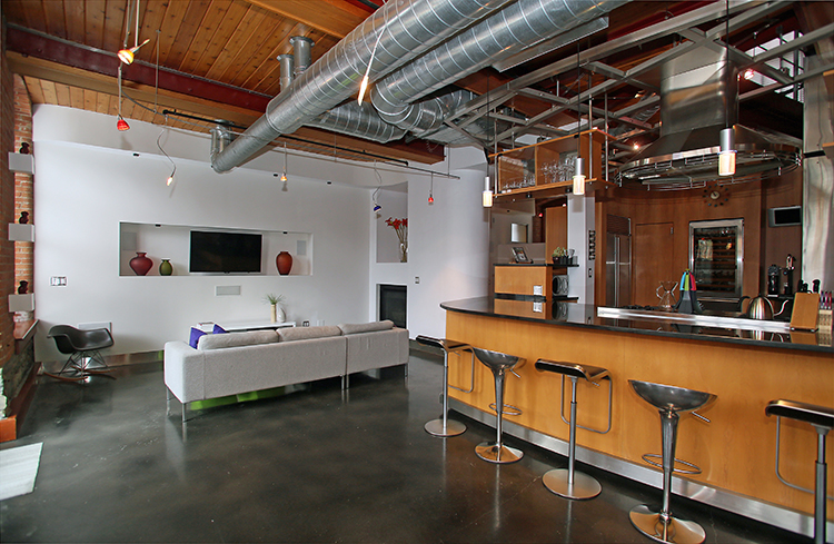 The kitchen, top, has a floating slate floor and built-in Miele espresso maker. The staircase, above, leads to a wall of blue glass.