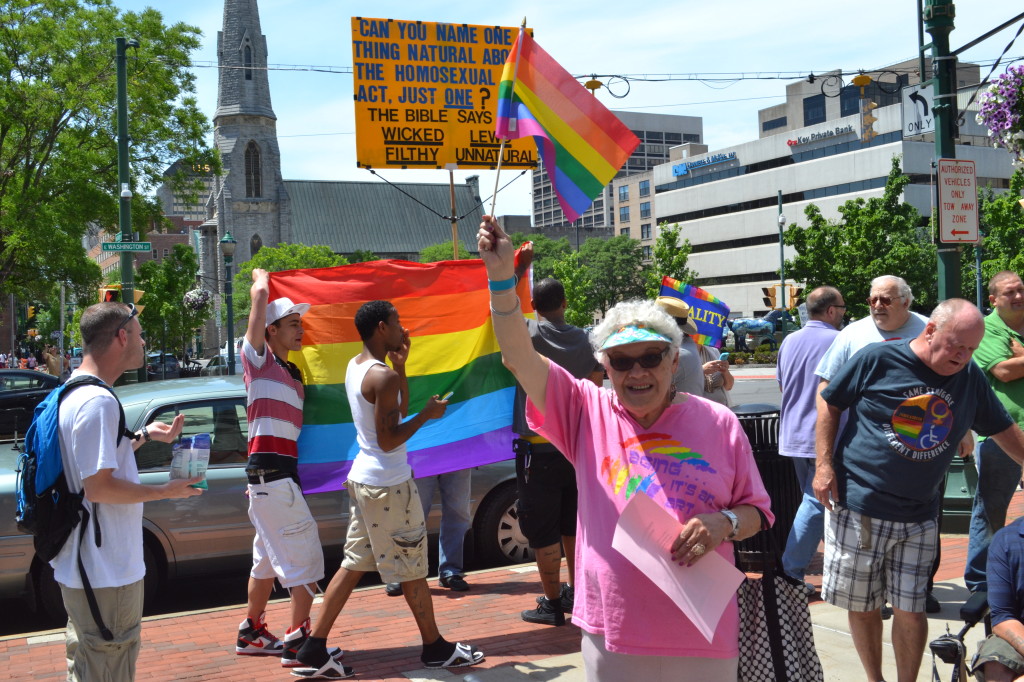 Attendees block the lone protestor who showed up for the rainbow flag raising over city hall. (Photo by Ty Marshal)
