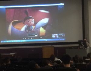 On the right, behind a podium and desktop computer is the professor: Timothy Coolbaugh. Photo: Joe Cunningham