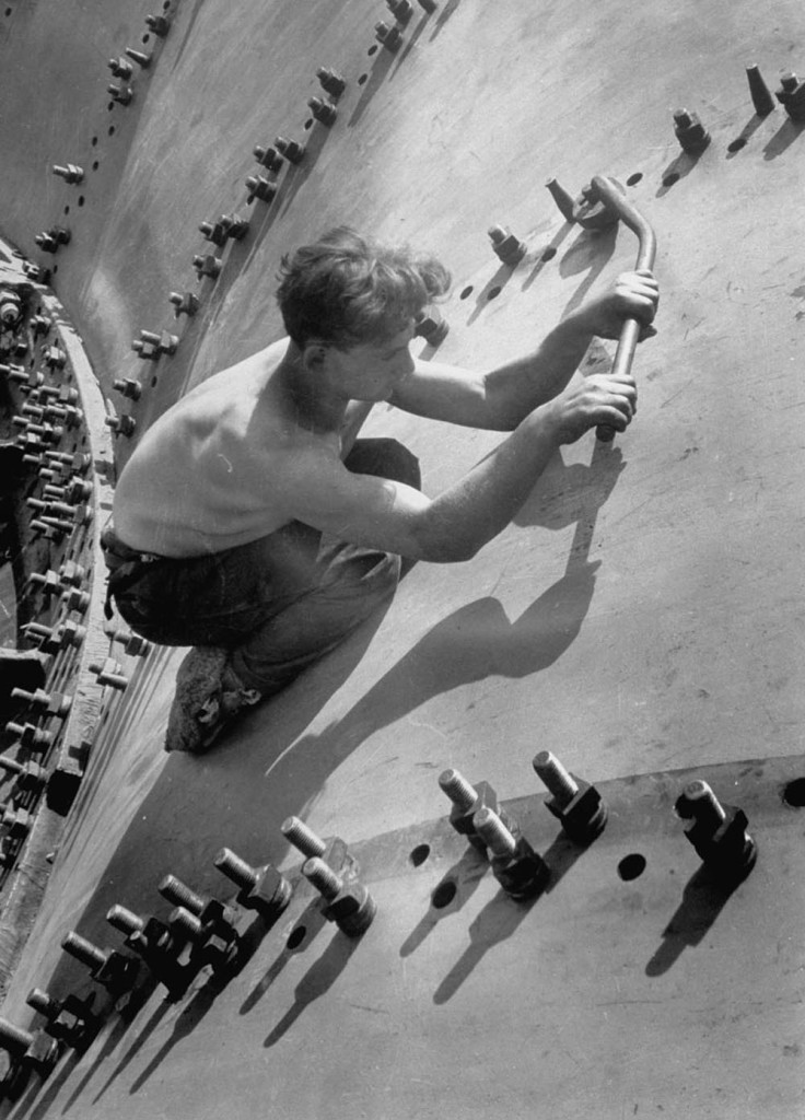 Circa 1930: Russian worker using large wrench to tighten nut on of the huge bolts used in the construction of a generator shell for the Dnieper River Dam. (Photo by Margaret Bourke-White/Time & Life Pictures/Getty Images)