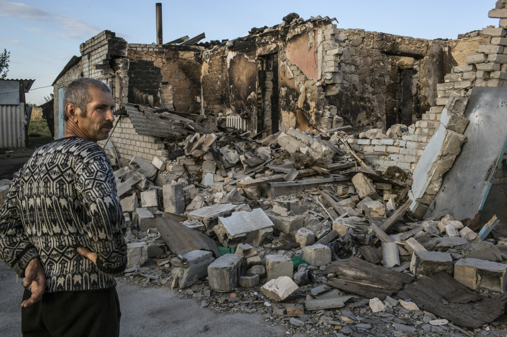 Vasiliy Goncharov outside the rubble of his home, destroyed during recent clashes between Ukrainian and pro-Russian forces, in Ilovaysk, Sept. 3, 2014. A recent devastating offensive mounted by Russian artillery units at the end of August has routed government forces, breaking what had been a relentless advance that had seemed on the verge of crushing the pro-Russian uprising in the country’s southeast. (Mauricio Lima/The New York Times)