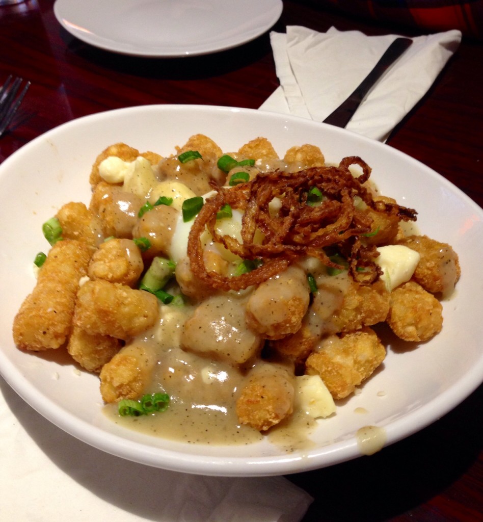 Breakfast Poutine -- tots, NY cheese curds, bourbon au poivre, poached egg, scallions and french-fried-frizzled onions. Photo: Christopher Malone