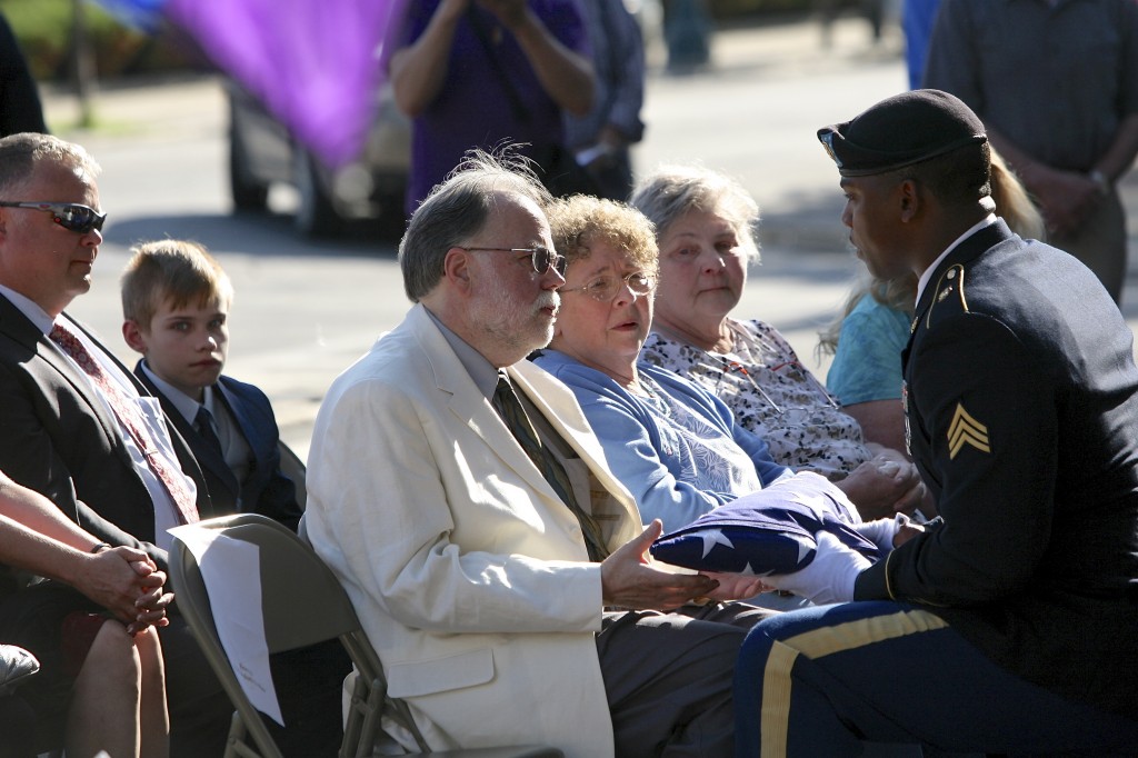 Joel Rinne being presented with a folded-up American flag at the ceremony. Photo by Michael Davis | Syracuse New Times
