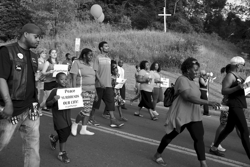 Marching past makeshift white crucifix on E. Fayette Street. Michael Davis Photo | Syracuse New Times